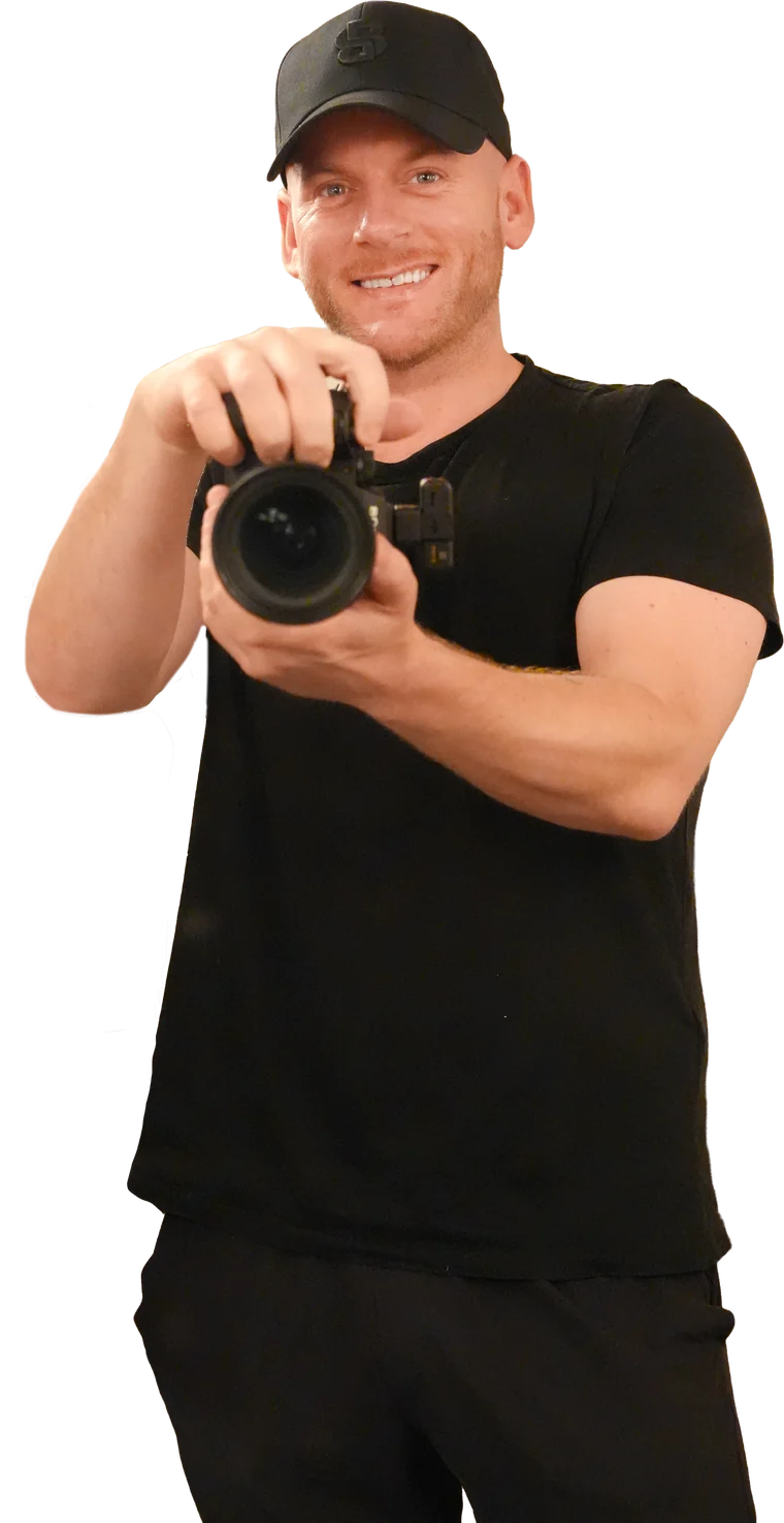 Kyle Burrows smiling and holding his camera